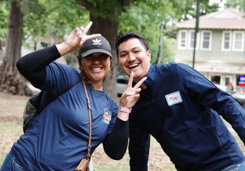 A man and a woman together outside posing for a funny photograph